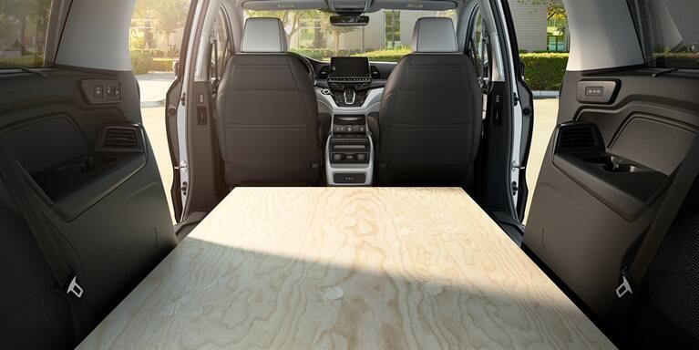 2027 Honda Odyssey Elite spacious cargo area with a sheet of plywood flat on the floor (Minivan).